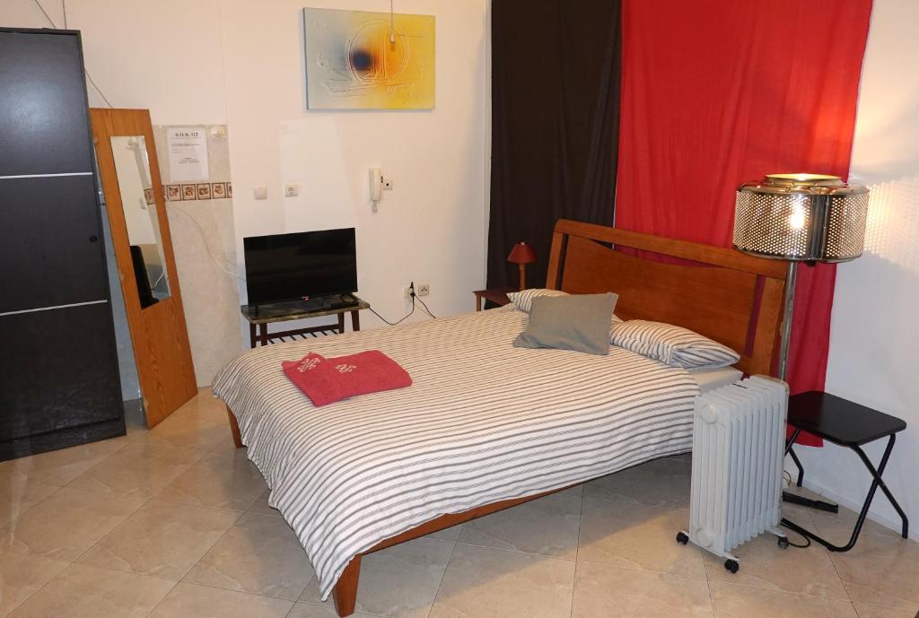 a bedroom with a large bed with a television at A Alegria Estúdio in Reguengos de Monsaraz