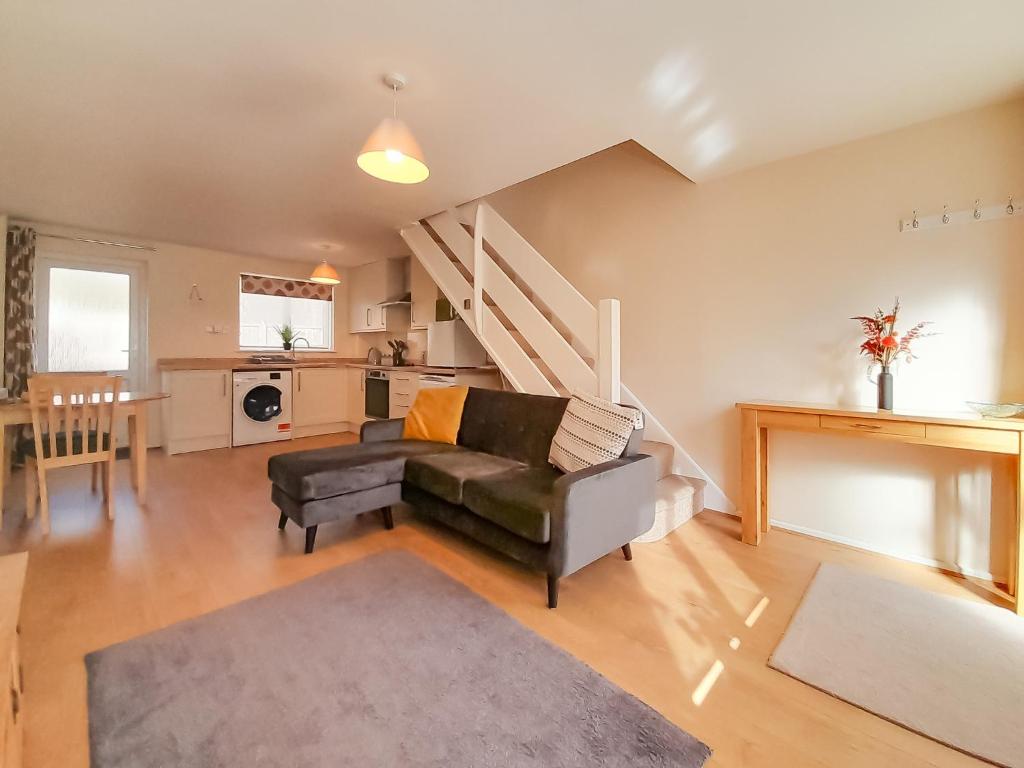 a living room with a couch and a table at Modern Cotswold Home in Witney