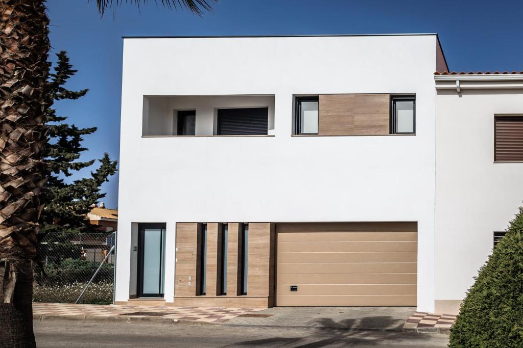 une maison blanche avec un garage dans l'établissement Apartamento Jambo Luxury, à Almendralejo