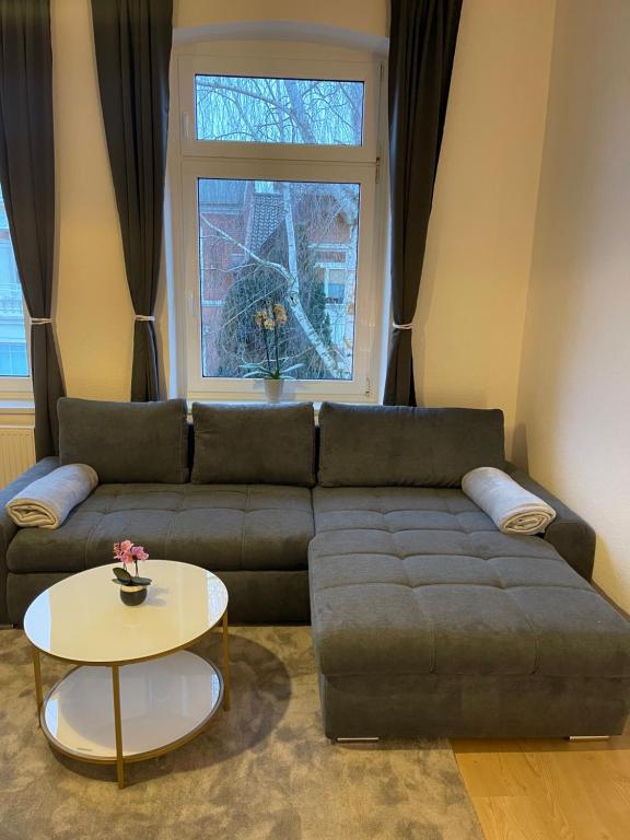 uma sala de estar com um sofá e uma mesa em Schöne Wohnung am Schlossgarten em Schwerin