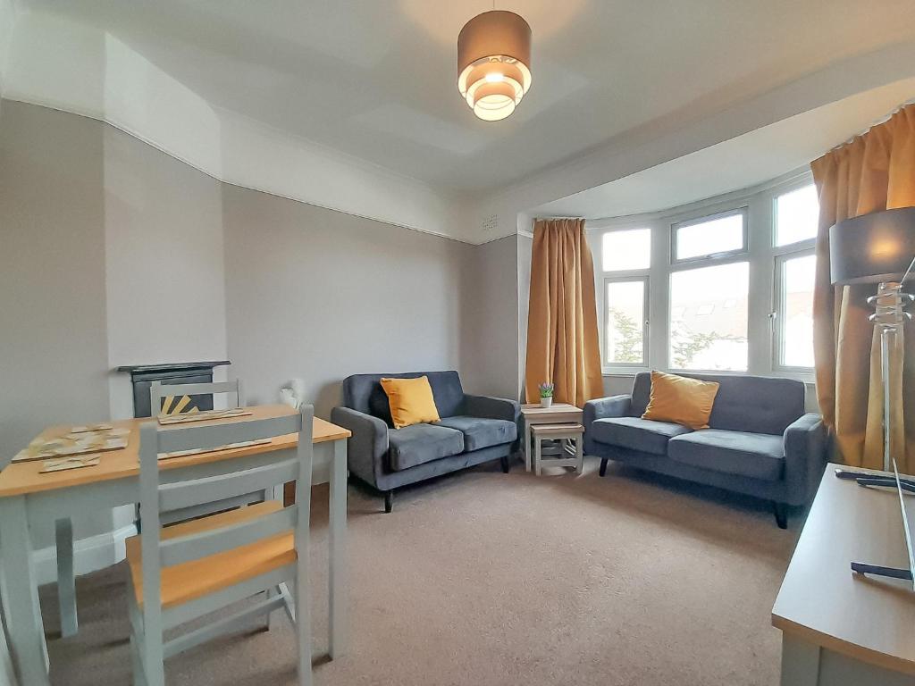 Rose Hill Apartment في أوكسفورد: غرفة معيشة مع كنبتين وطاولة