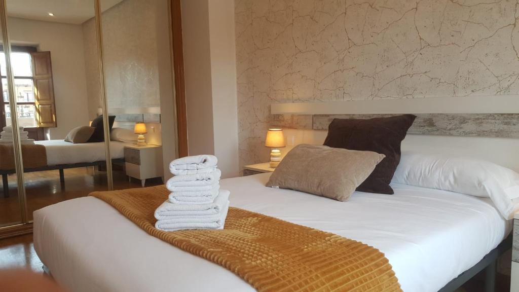 Un dormitorio con una cama con toallas. en Feeling Home Plaza Mayor, en León