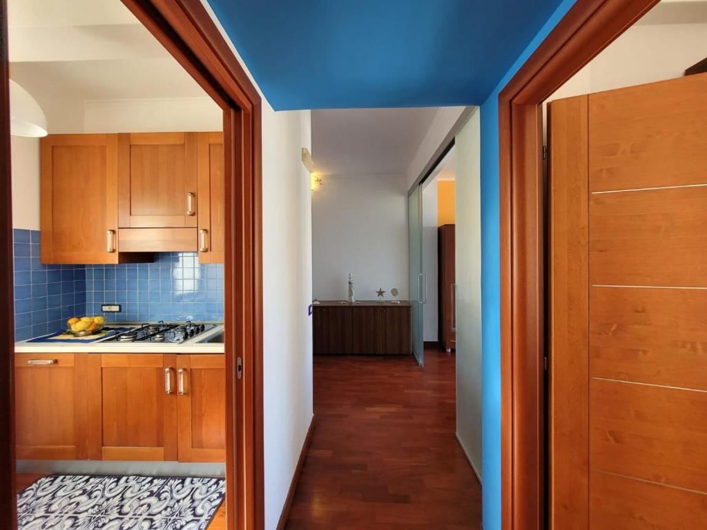 a kitchen with wooden cabinets and a blue ceiling at Sara blu apartment in Sorrento