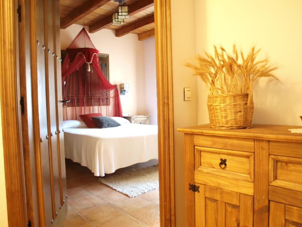 Un dormitorio con una cama y una cesta en un tocador en Casa Rural El Olivo, en Guijo de Granadilla