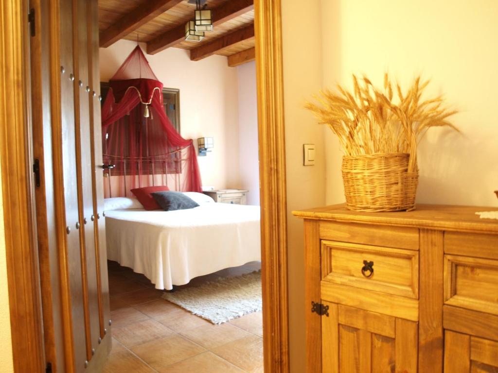 a bedroom with a bed and a basket on a dresser at Casa Rural El Olivo in Guijo de Granadilla