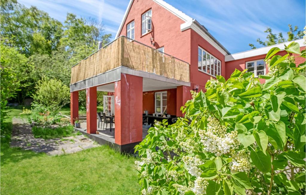 a red house with a garden in front of it at Cozy Apartment In Gudhjem With Kitchen in Gudhjem