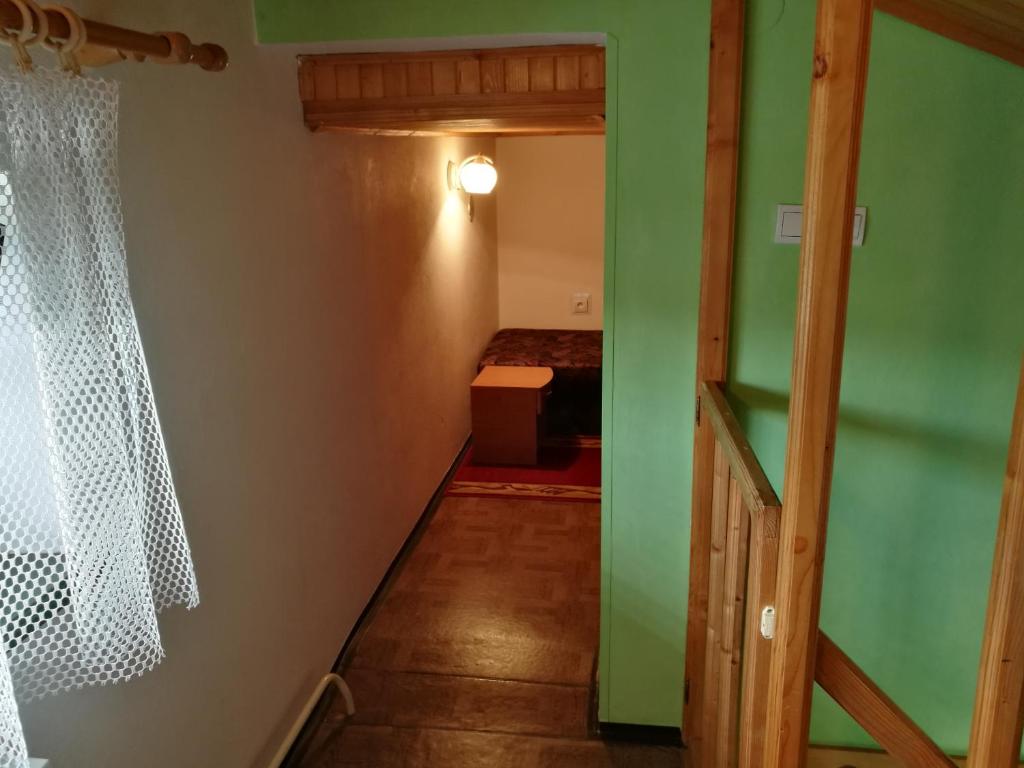 a hallway with a green door and a bedroom at Ubytovanie v súkromí Zelený dom in Vyšné Ružbachy
