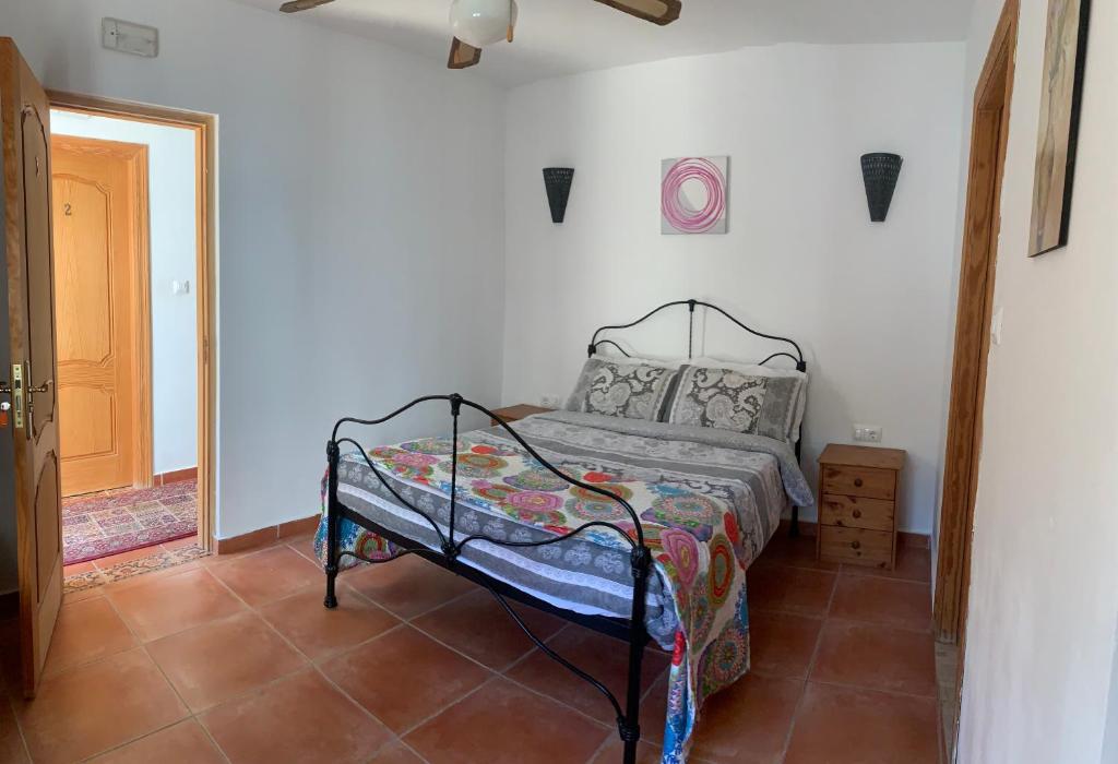 a bedroom with a bed in a white room at Lavender Lodge Almeria in Arboleas