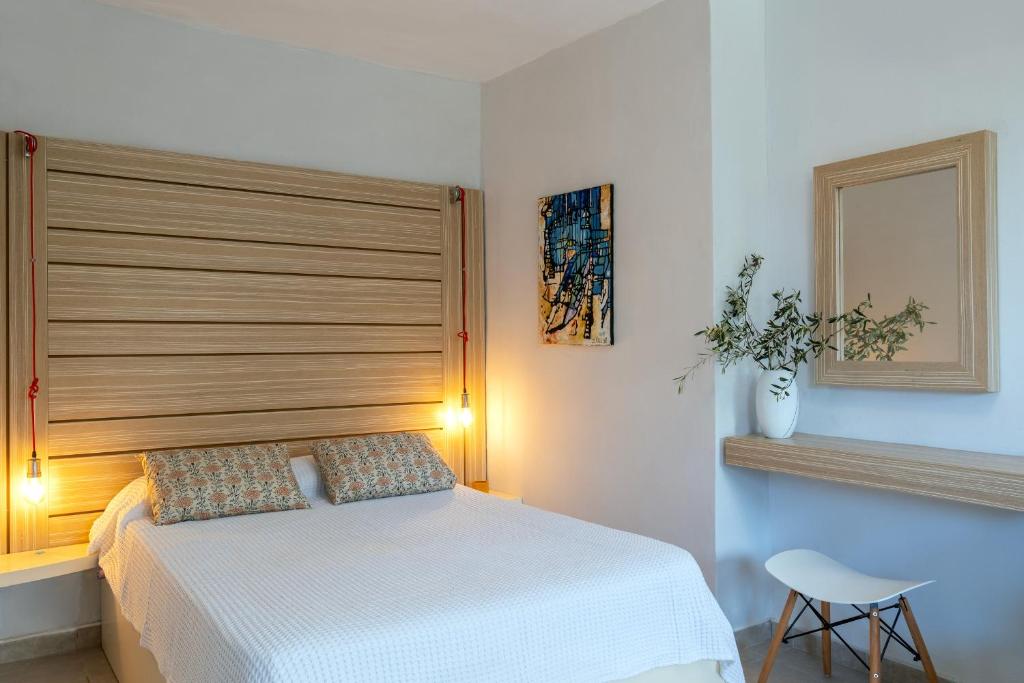 um quarto com uma cama branca e uma cabeceira em madeira em Coco Studio em Chania Town