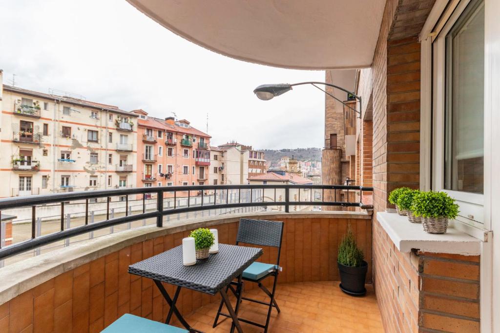 uma varanda com uma mesa e cadeiras e uma vista em Casco Viejo junto a BilboRock em Bilbau
