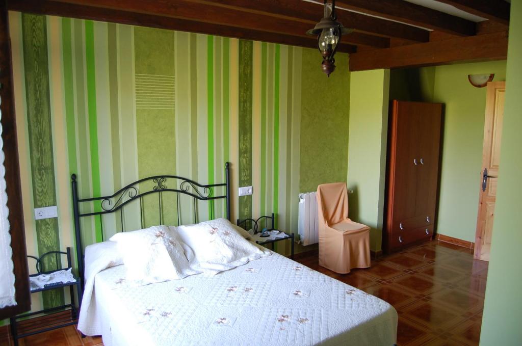 - une chambre avec un lit et une chaise dans l'établissement Hosteria El Corralucu, à Serdió