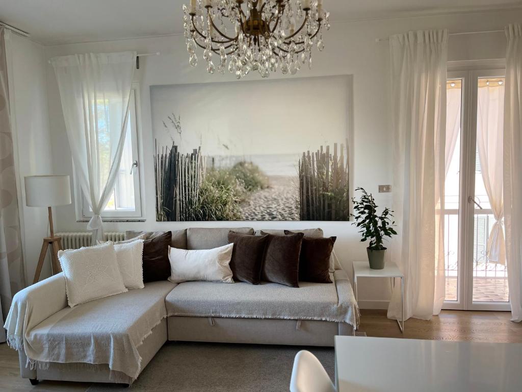 a living room with a couch and a chandelier at Family Apartment 2 Sirmione in Sirmione