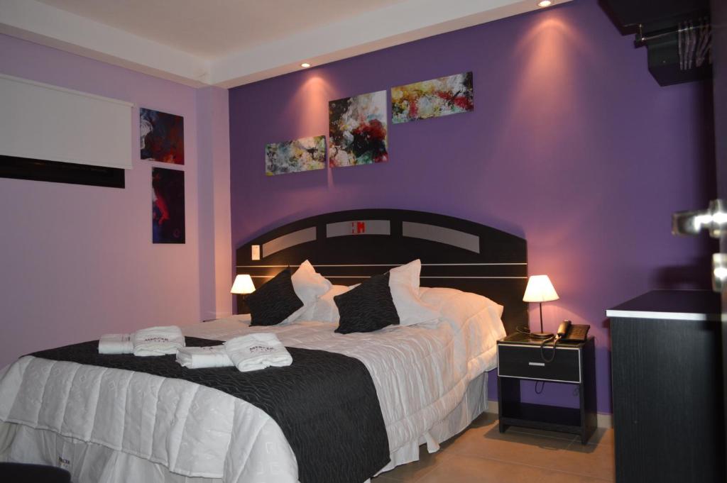 um quarto com uma cama grande e paredes roxas em Mercer Hostal em San Miguel de Tucumán