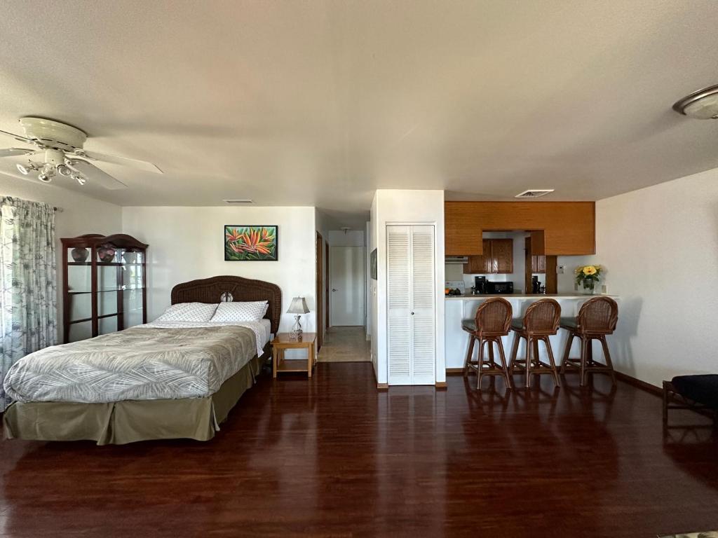 a bedroom with a large bed and a kitchen at Haukea at Kona Joe Coffee Farm in Kealakekua