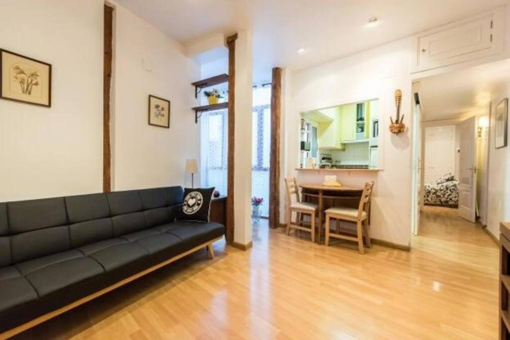 a living room with a black couch and a table at Luminoso Apartamento en Lavapiés-Tirso de Molina in Madrid