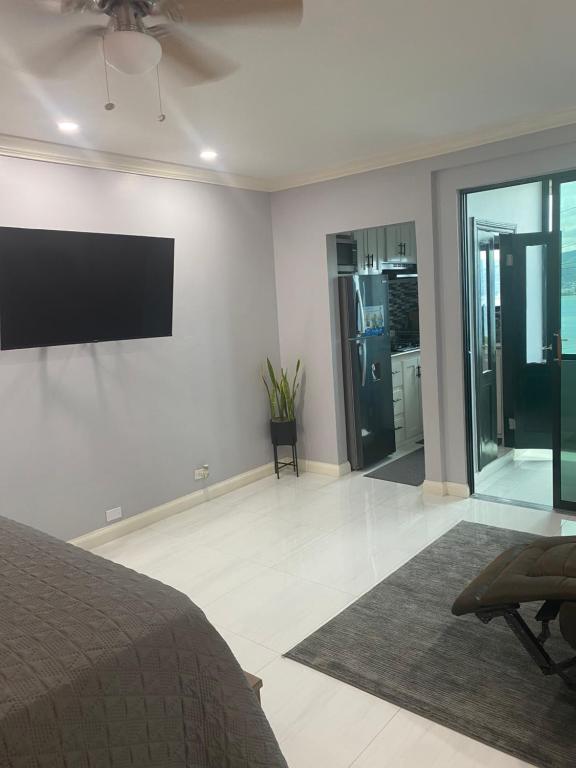 - une chambre avec un lit et une télévision murale à écran plat dans l'établissement K&S SEAVIEW luxury apartment, à Montego Bay
