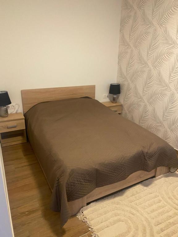 een bed in een slaapkamer met 2 nachtkastjes en 2 lampen bij Beugró Lak in Esztergom