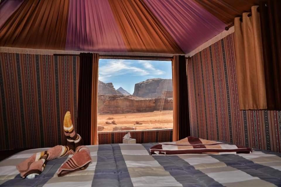 a bedroom with a bed with a view of the desert at Tareqzwy wadi rum in Wadi Rum