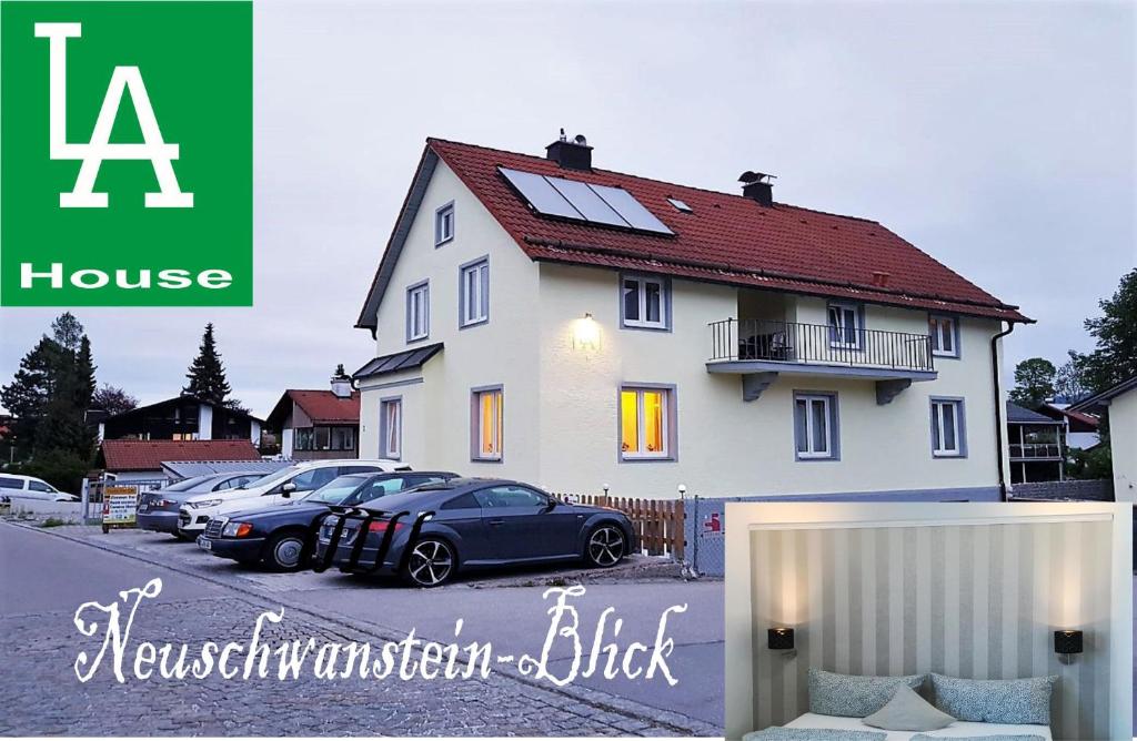 a house with cars parked in a parking lot at House LA Neuschwanstein Blick in Füssen