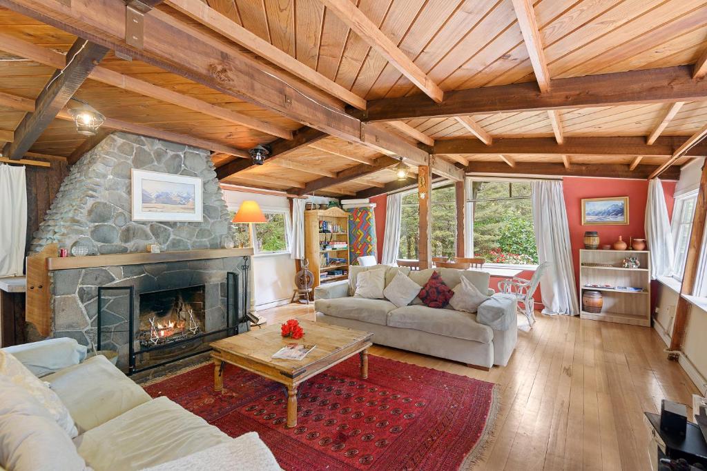 una sala de estar con chimenea de piedra en una casa en Holiday Chalet in Arthurs Pass, en Arthur's Pass