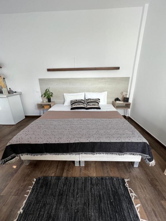 a bedroom with a large bed with a black rug at Fatolitis Studios in Masouri
