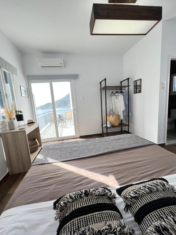 a bedroom with a large bed and a large window at Fatolitis Studios in Masouri