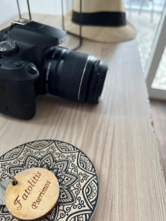 a camera on a table next to a wooden plate with a label at Fatolitis Studios in Masouri