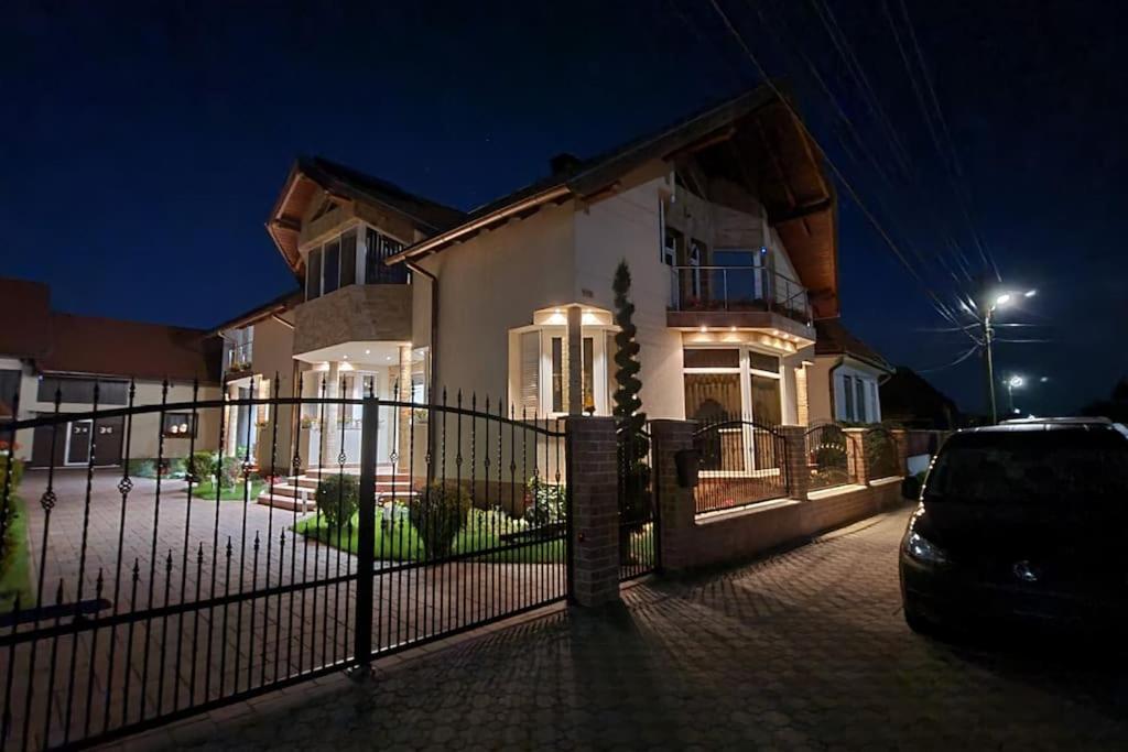 a house with a fence in front of it at night at MeLux Airport House 