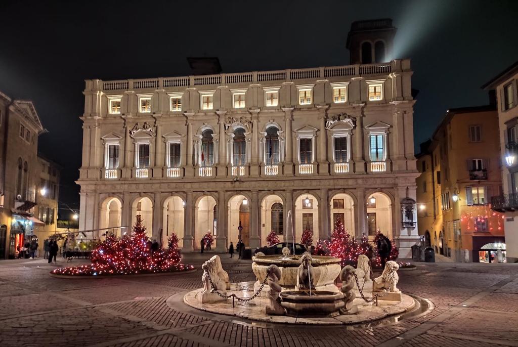 a large building with a fountain in front of it at RUBY HOME Città Alta in Bergamo