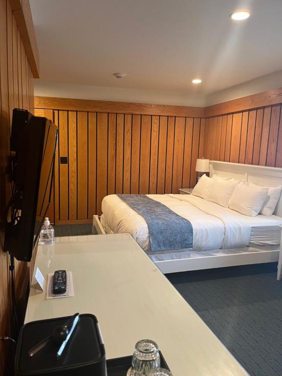a bedroom with a bed and a desk with a television at The Leland Lodge 