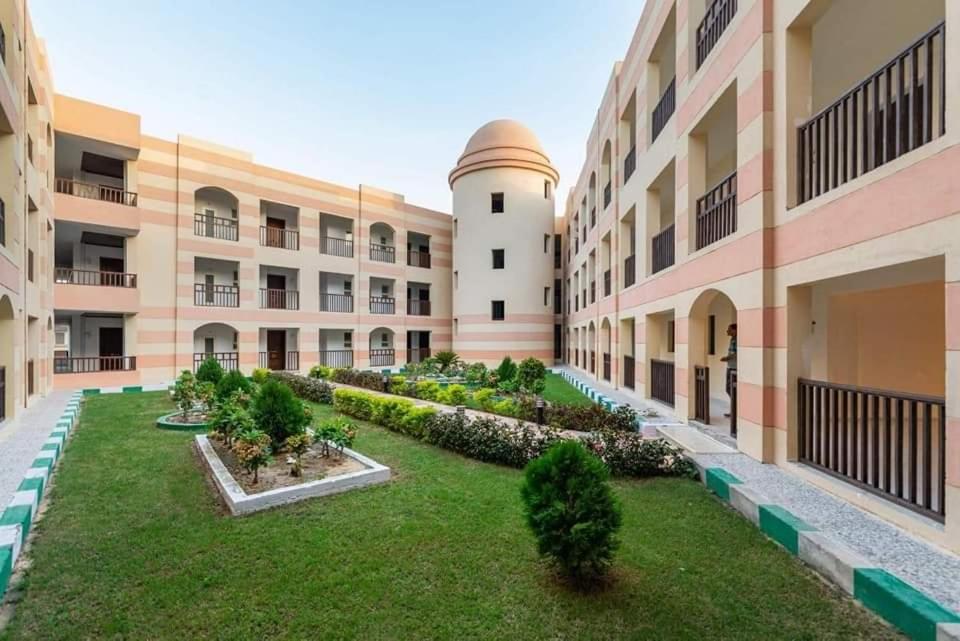 een lege binnenplaats van een appartementencomplex met een tuin bij One bedroom apartment at marina city portghalib in Port Ghalib
