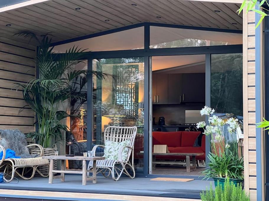 un porche cubierto con mesa y sillas en Luxe vakantiehuis “Saalien”, en Beekbergen