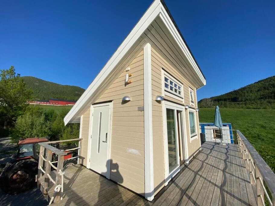 une petite maison sur une terrasse en bois dans l'établissement Minihus med drømmeutsikt til Sunnmørsalpene, à Aure