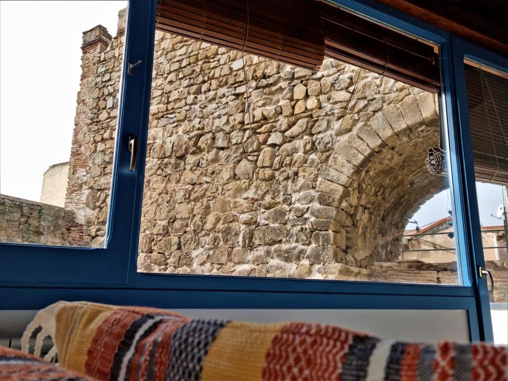a stone wall seen through a window at Casa Albarrana in Talavera de la Reina