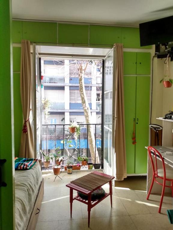 Habitación con pared verde, ventana y mesa. en Departamento Sarmiento Zona Aldrey en Mar del Plata