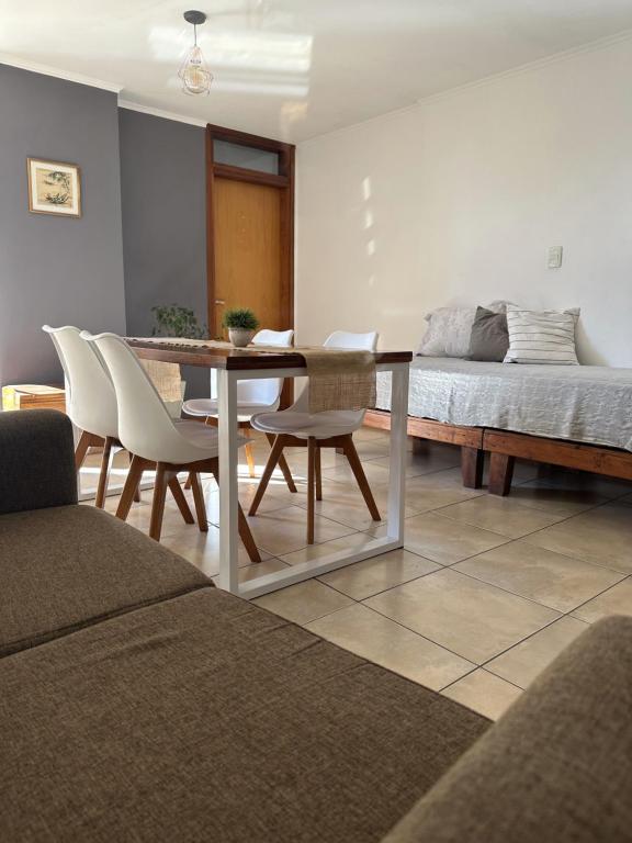 a living room with a table and chairs and a bed at Dpto Paraná - Piscina, calefacción y aire acond in Cordoba