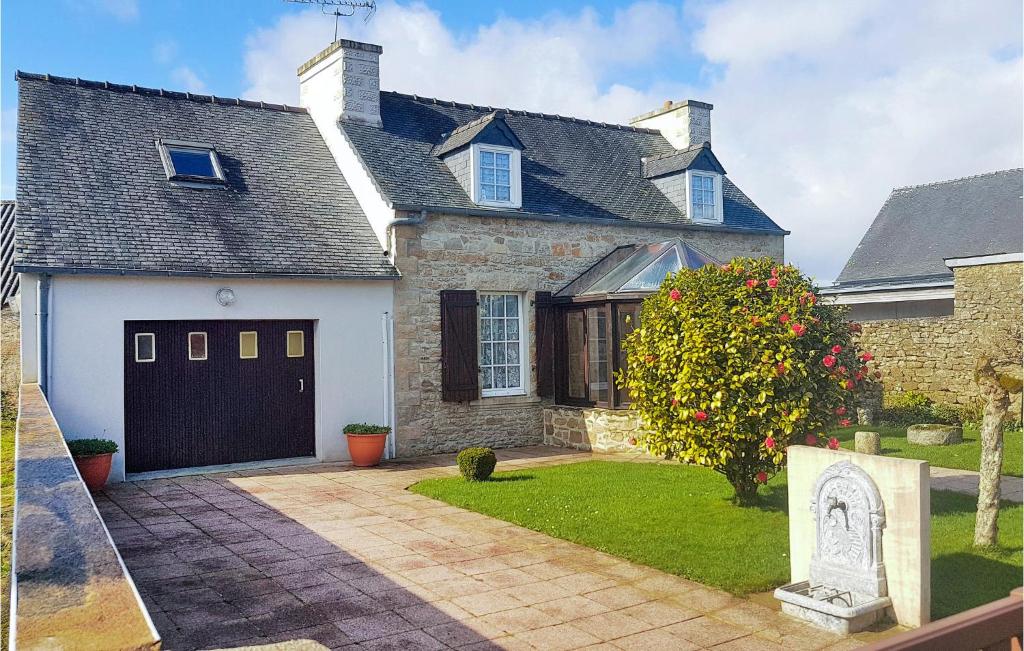 une grande maison en briques avec un garage et une tombe dans l'établissement Beautiful Home In Le Cloitre S Thegonnec With Kitchen, à Le Cloître-Saint-Thégonnec