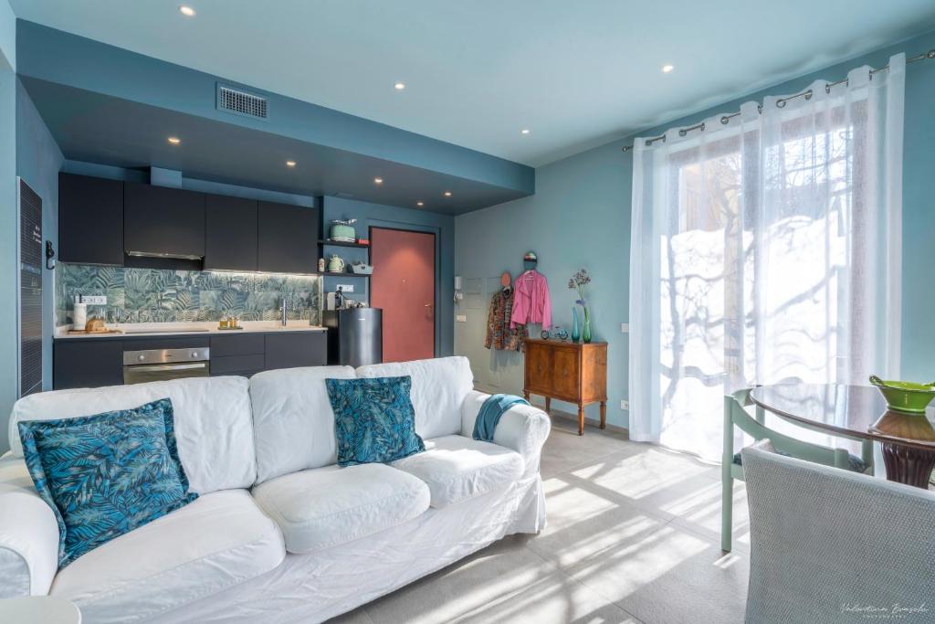 salon z białą kanapą i kuchnią w obiekcie Draisina Bike Apartments DUE w mieście Oleggio Castello