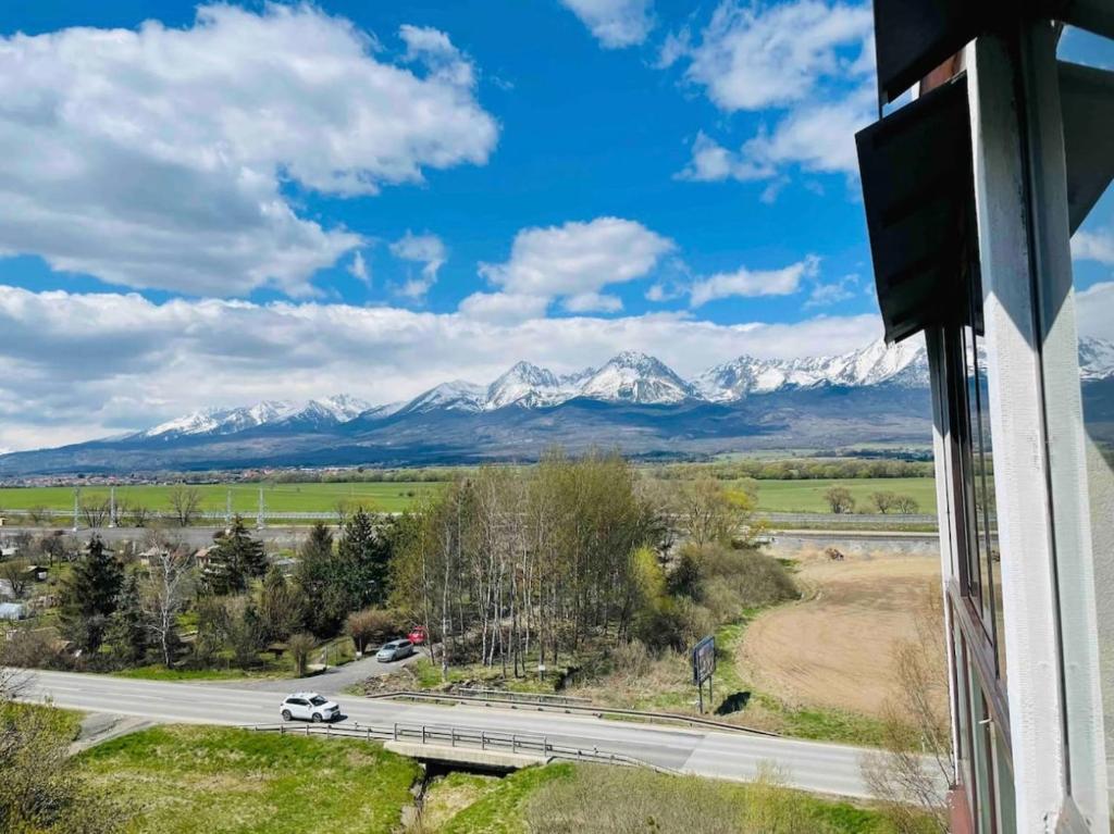 a road with a view of snow covered mountains at Svit apartment High Tatras in Svit