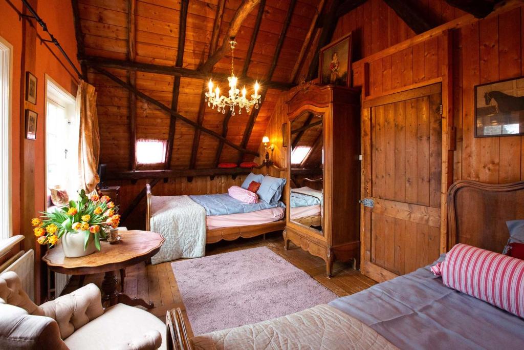 una habitación con 2 camas y una mesa en una cabaña en B&B Het Gasthuys en Amerongen
