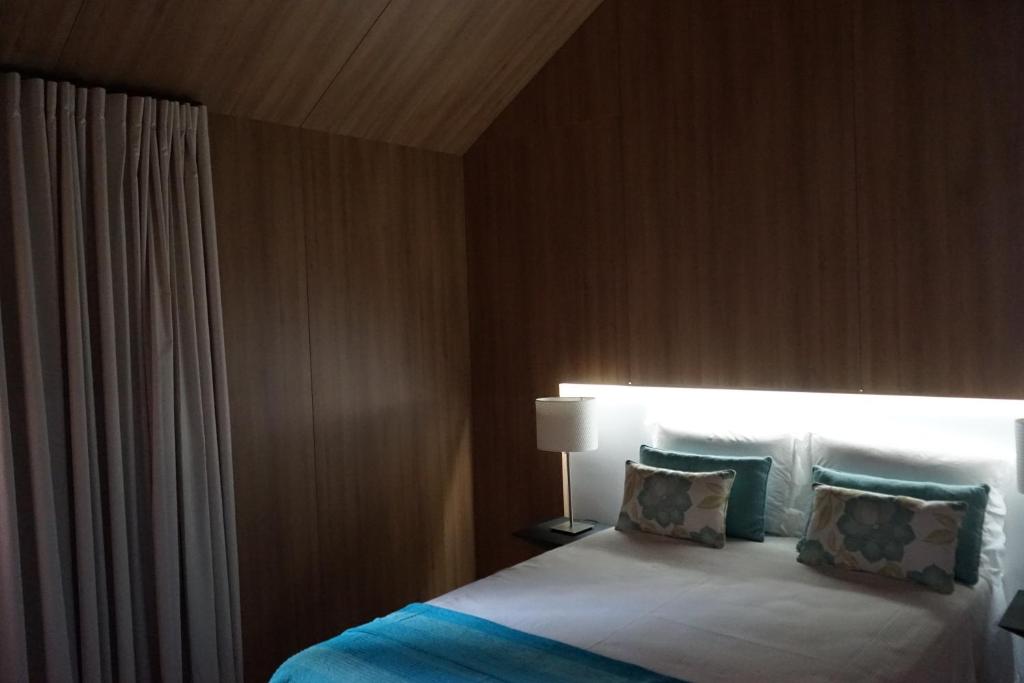 1 dormitorio con 1 cama con luz encendida en As Cabanas dos Netinhos, en Eirado
