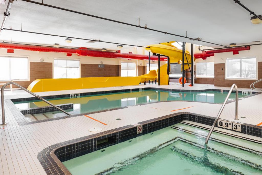 an indoor swimming pool in a building with a swimming pool at Home Inn and Suites Lloydminster in Lloydminster