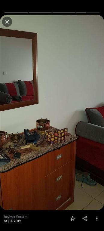 een kamer met een dressoir met een spiegel en een bed bij Ne reservez pas svp plus disponible in Tanger