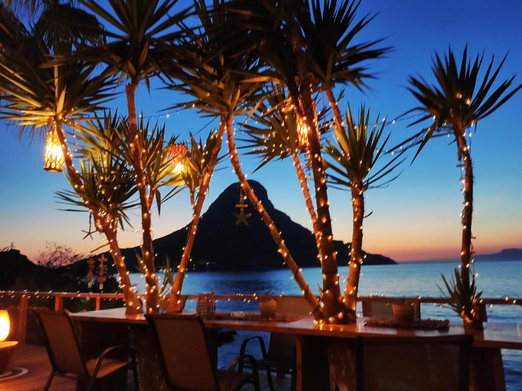 a table with palm trees on the beach at night at Fatolitis Studios in Masouri