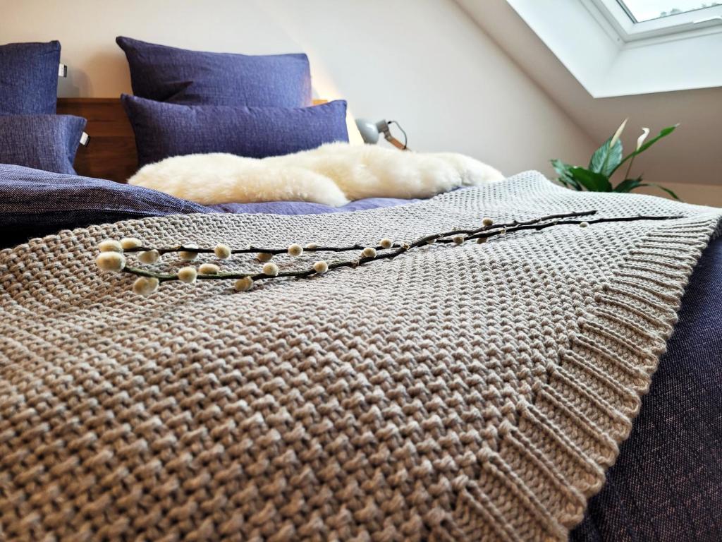 a bed with a blanket and beads on it at Seezeit - gemütliche Ferienwohnung, Tiefgarage, Cospudener See in Markkleeberg