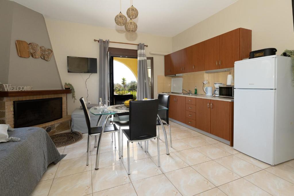 a kitchen with a table and chairs and a white refrigerator at Elaionas Studios in Gythio