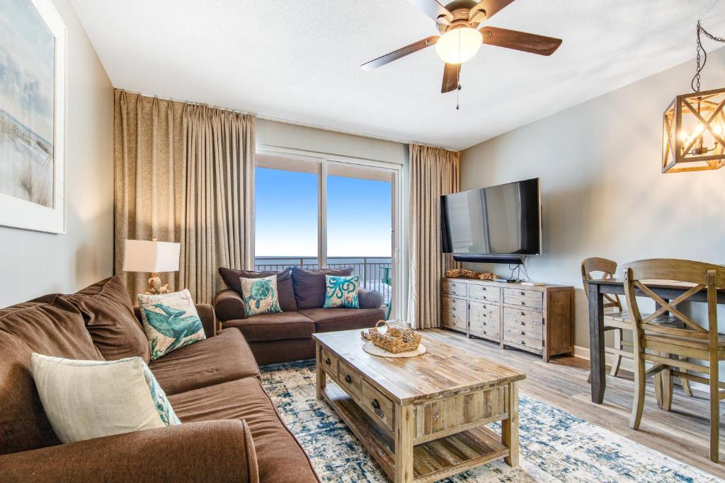 a living room with a couch and a tv at Sterling Reef 902 in Panama City Beach