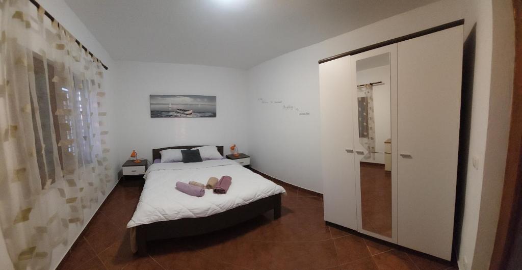 ein Schlafzimmer mit einem Bett mit zwei Schuhen drauf in der Unterkunft Apartman Vukoja Pakostane in Pakoštane