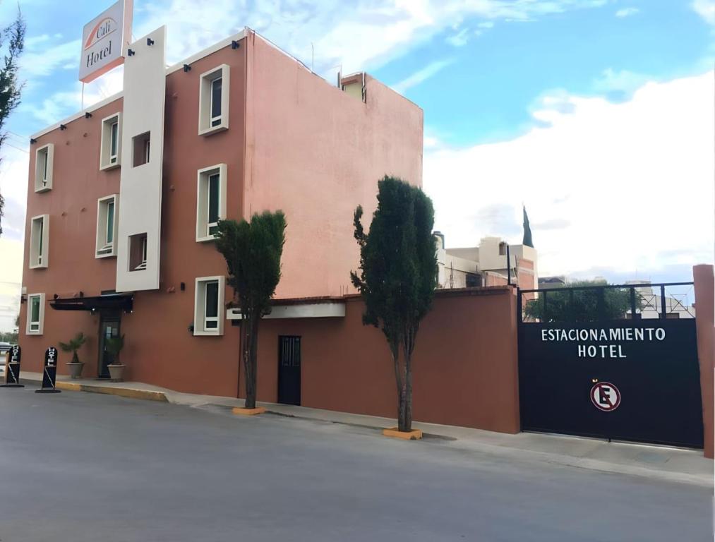 un bâtiment rose avec deux arbres devant lui dans l'établissement Hotel Cali Blvd., à Guadalupe