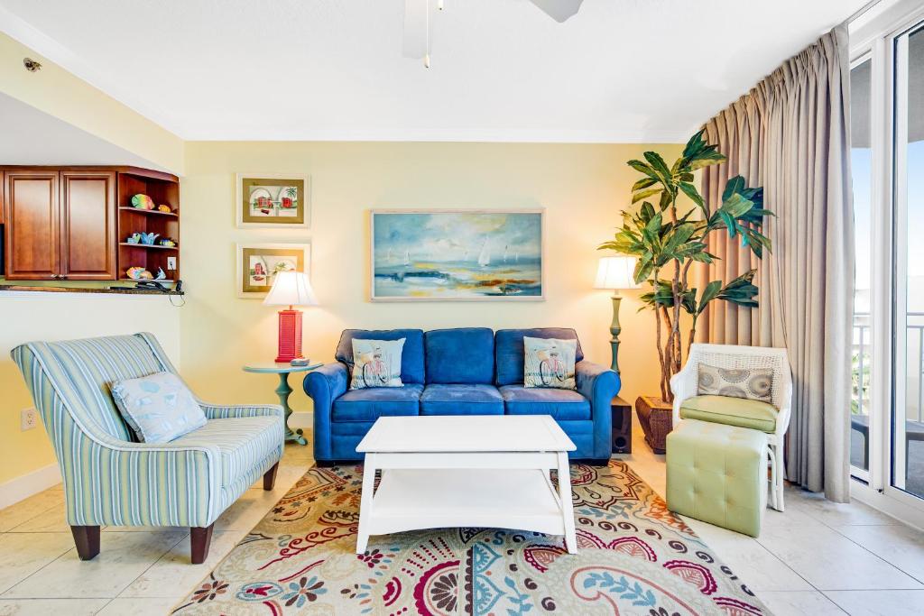 a living room with a blue couch and chairs at Waterscape B624 in Fort Walton Beach